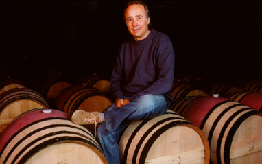 Joan Manuel Serrat sobre unas barricas de Mas Perinet